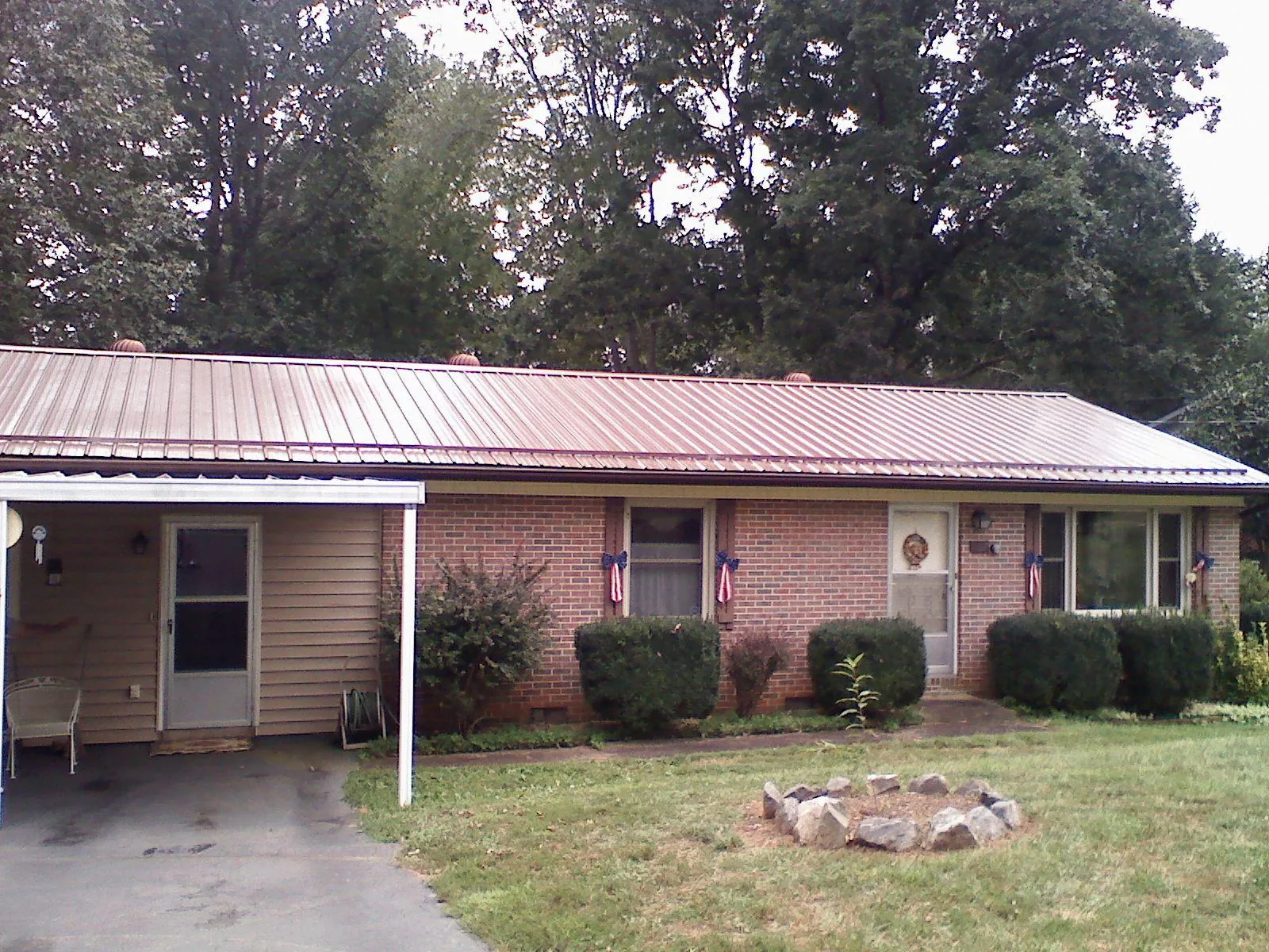 Bronze metal roof and carport on a brick ranch home — Roof Repair work by our crew in Galt